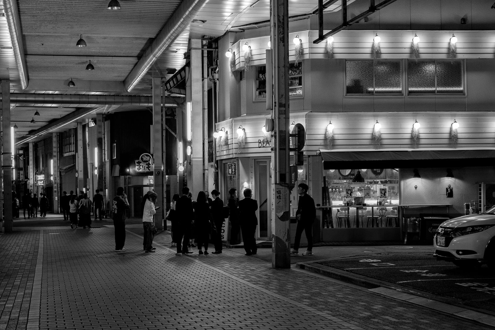 夜の小松駅前、商店街に集う人々